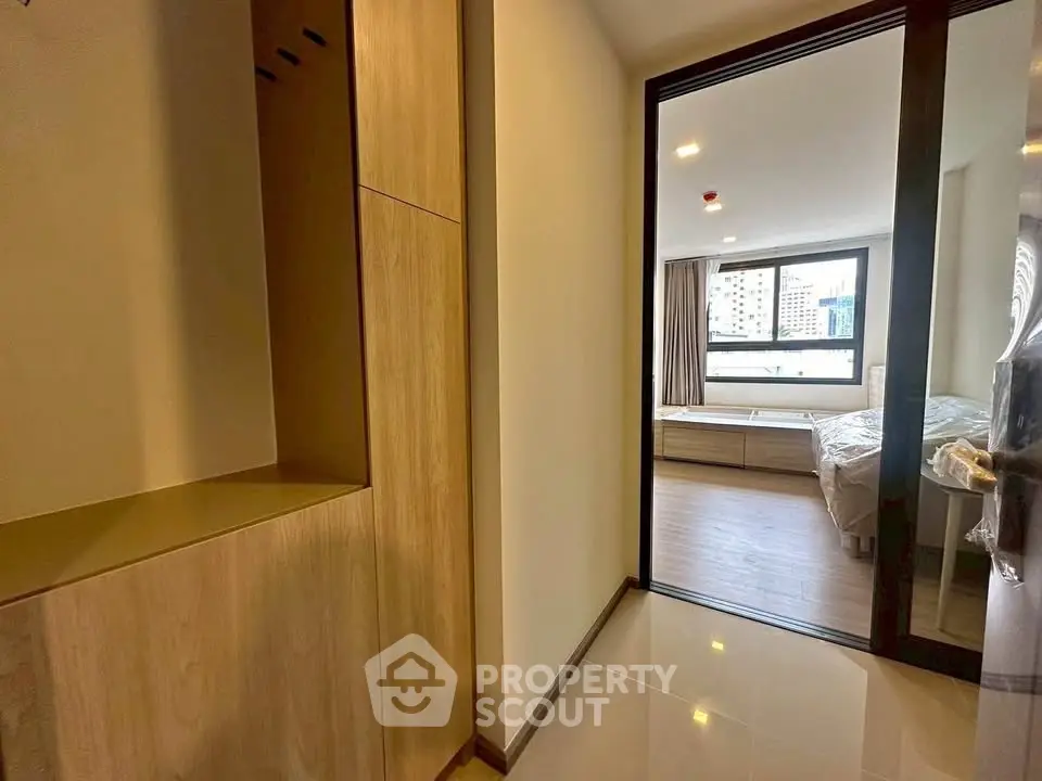 Modern apartment interior with wooden accents and large window view.