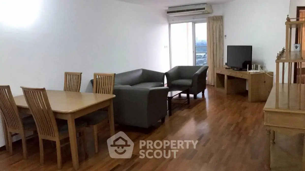 Spacious living room with modern furniture and wooden flooring, perfect for family gatherings.