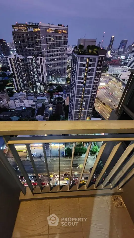 Stunning cityscape view from a high-rise balcony at dusk, showcasing urban living with vibrant city lights.