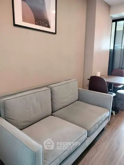 Cozy living room with modern sofa and dining area, perfect for relaxation and entertaining.