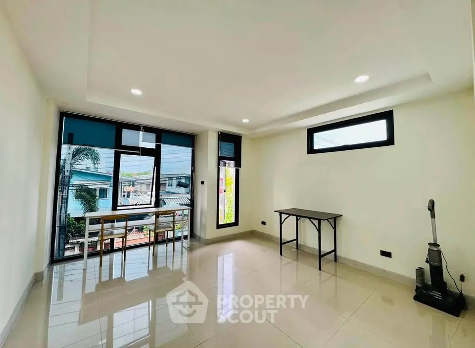 Spacious and bright living room with large windows and modern furnishings.