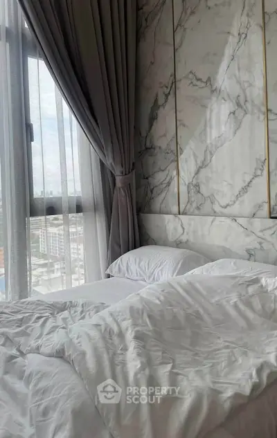 Luxurious bedroom with marble accent wall and city view