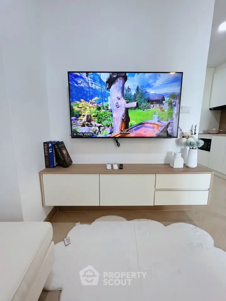 Modern living room with wall-mounted TV and sleek white furniture