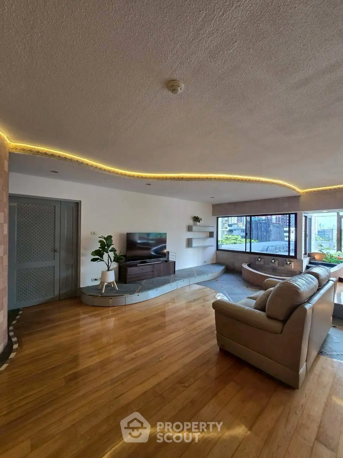 Spacious living room with modern decor and large windows offering natural light.