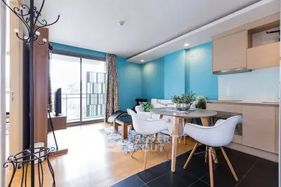 Modern living room with open kitchen and stylish decor, featuring a balcony view.