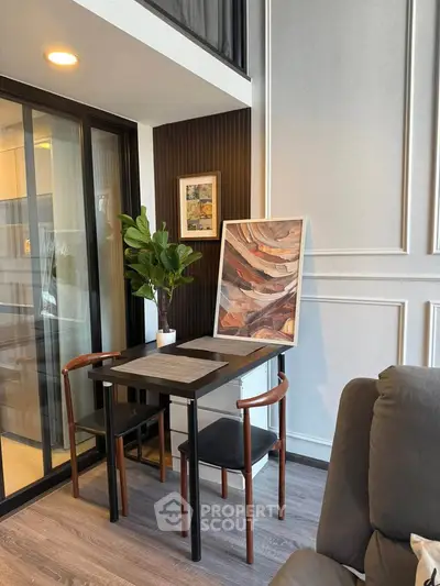Modern living room with stylish decor and cozy seating area, featuring elegant artwork and indoor plant.