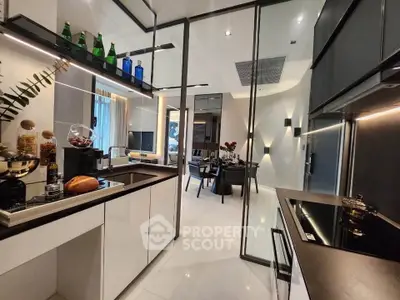 Modern open-layout kitchen with sleek design and dining area view, featuring contemporary appliances and stylish decor.