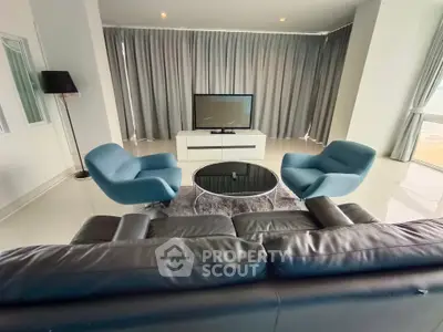 Luxurious modern living room with sleek furniture and large windows.