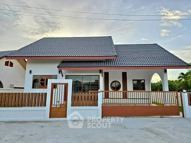 Charming modern house with a sleek roof and stylish wooden fence, perfect for family living.