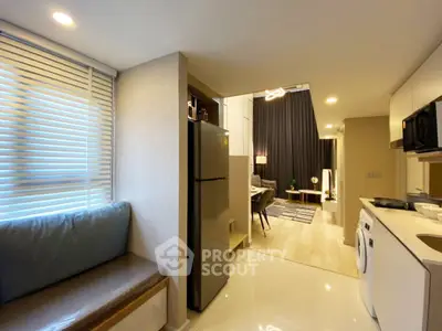 Modern open-layout kitchen with sleek appliances and cozy seating area in a stylish apartment.