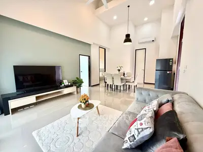 Modern living room with sleek furniture and open layout, featuring a cozy sofa and dining area.