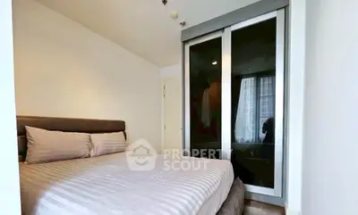 Modern bedroom with sleek sliding door wardrobe and cozy bed setup.
