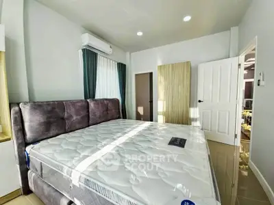 Spacious bedroom with plush bed and modern decor, featuring ample natural light and sleek design.