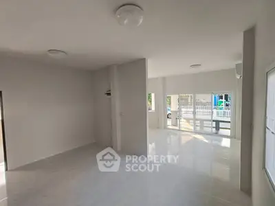 Spacious open-plan living area with large windows and natural light