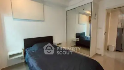 Cozy bedroom with mirrored wardrobe and modern minimalist design.