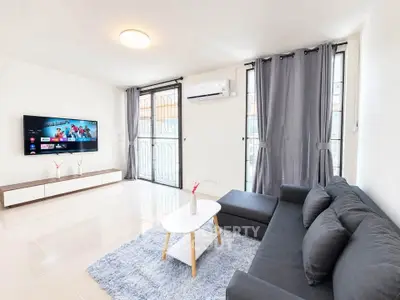 Modern living room with sleek furniture and wall-mounted TV, featuring large windows and stylish decor.