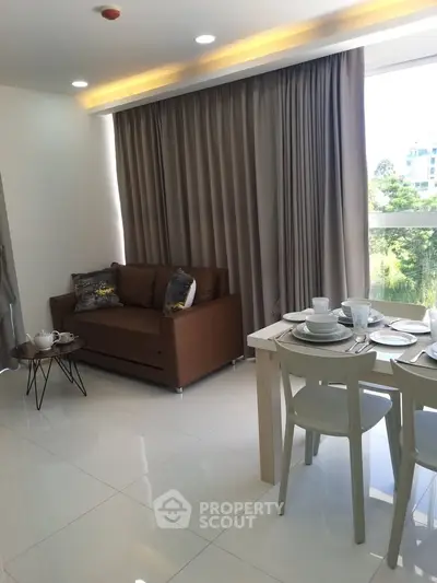 Modern living room with elegant dining set and cozy sofa, featuring large windows and stylish decor.