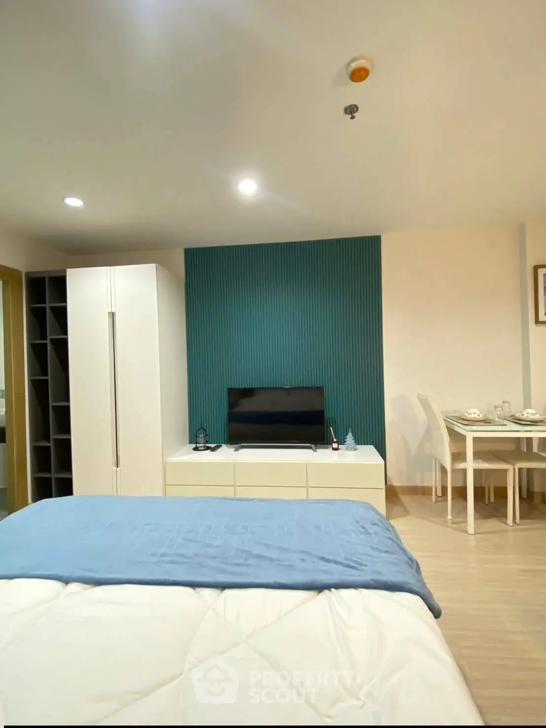 Modern bedroom with stylish decor and dining area in open layout apartment.
