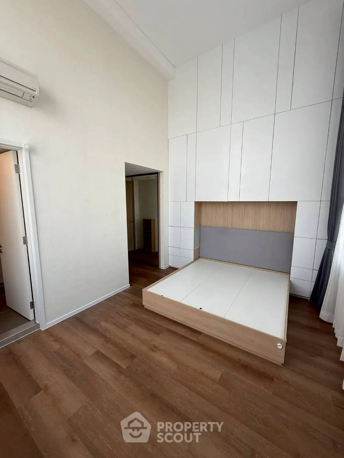 Spacious modern bedroom with built-in storage and wooden flooring