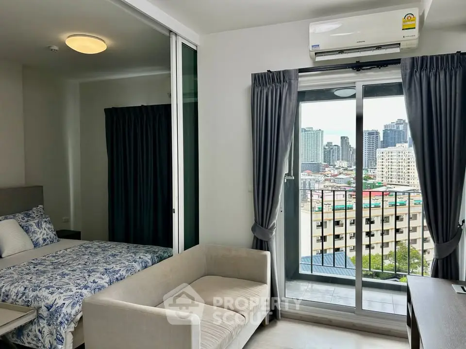 Modern apartment with city view from balcony, featuring cozy living area and bedroom.