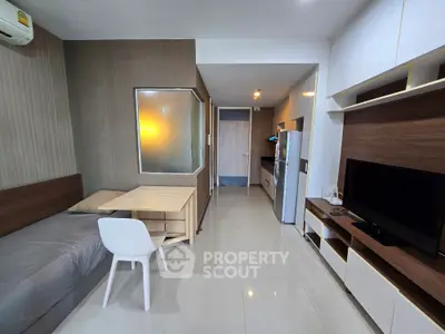 Modern studio apartment with sleek design and open layout, featuring a cozy living area and compact kitchen.