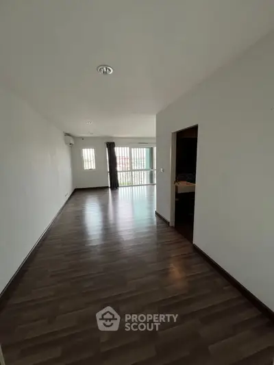 Spacious empty living room with wooden flooring and natural light