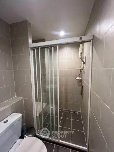 Modern bathroom with sleek shower enclosure and tiled walls, perfect for a contemporary home.