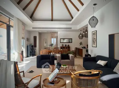 Spacious living room with high ceilings and elegant decor, featuring modern furniture and natural light.