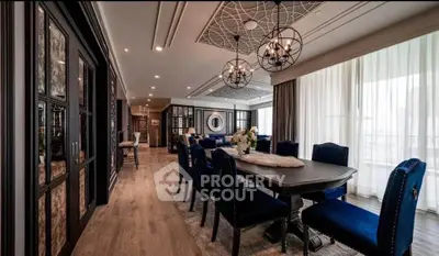 Luxurious dining room with elegant decor and blue velvet chairs in a modern apartment.