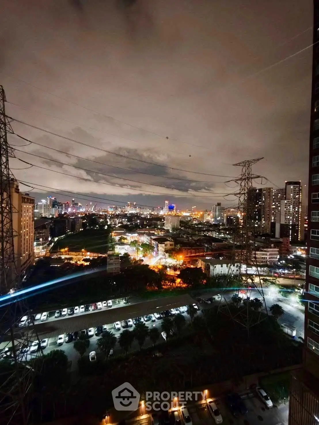Stunning cityscape view from high-rise apartment balcony at night, showcasing vibrant urban lights.