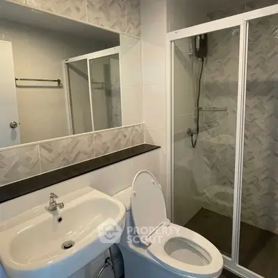 Modern bathroom with shower enclosure and sleek fixtures.