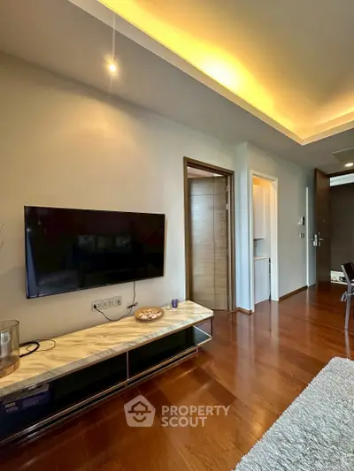 Modern living room with sleek TV setup and wooden flooring