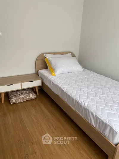 Cozy minimalist bedroom with wooden flooring and modern furniture