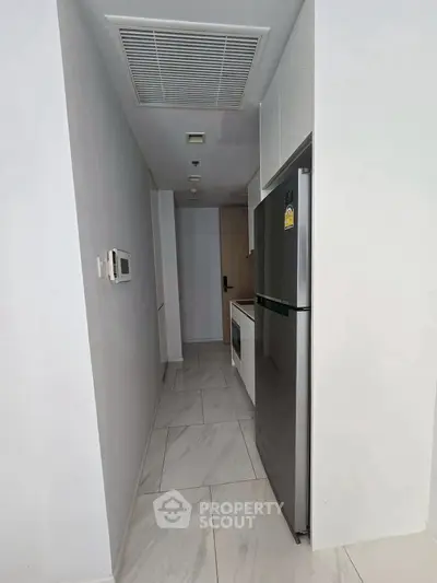 Modern narrow kitchen with sleek appliances and minimalist design