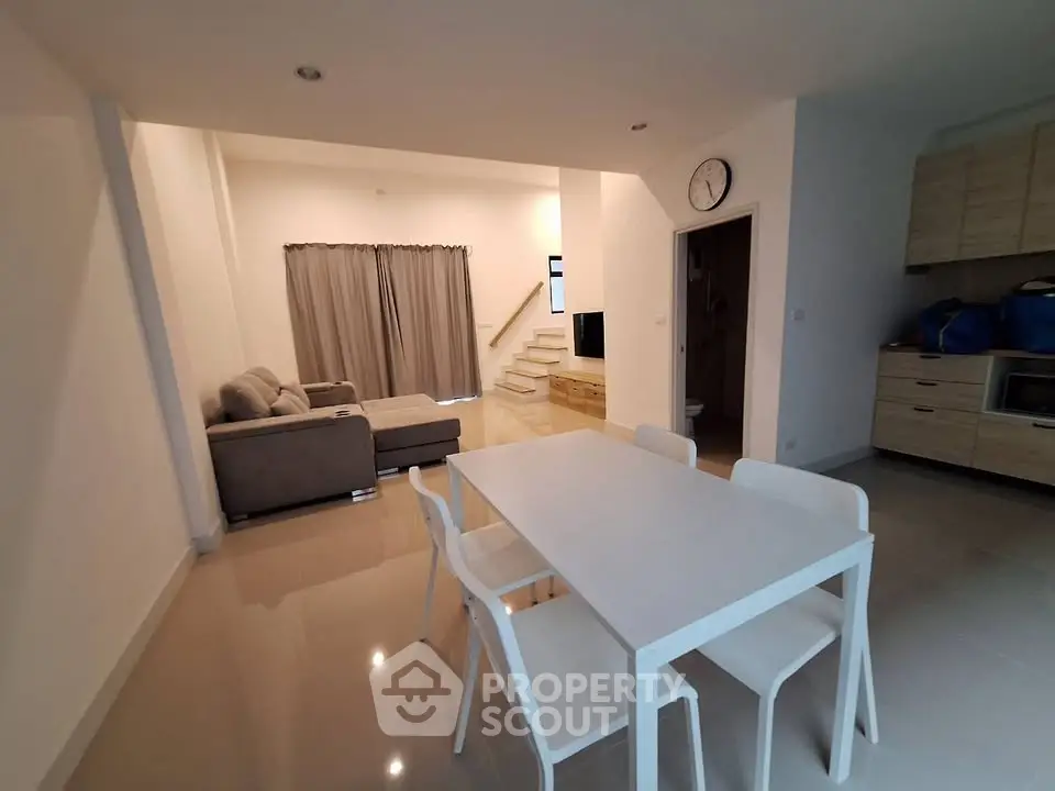Modern open-plan living and dining area with sleek furniture and neutral tones.