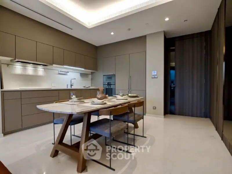 Modern kitchen with sleek cabinetry and dining table in luxury apartment