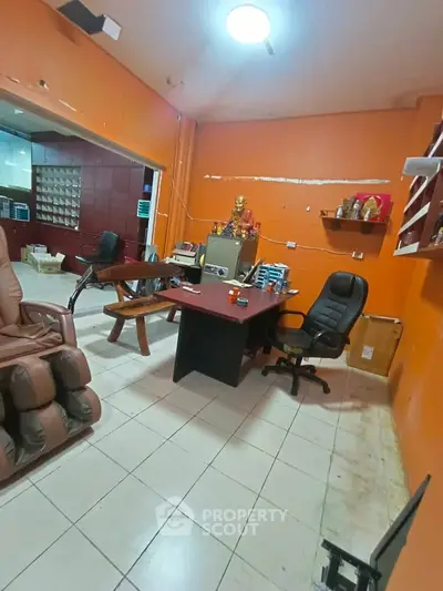 Spacious office space with orange walls, ergonomic chairs, and ample storage, ideal for productivity.