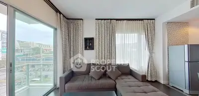 Modern living room with large windows and stylish sectional sofa, offering a bright and inviting atmosphere.