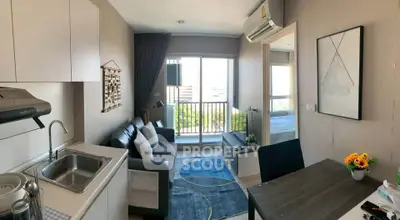 Modern apartment interior with open layout, featuring a cozy living room and kitchen area, leading to a balcony with city views.