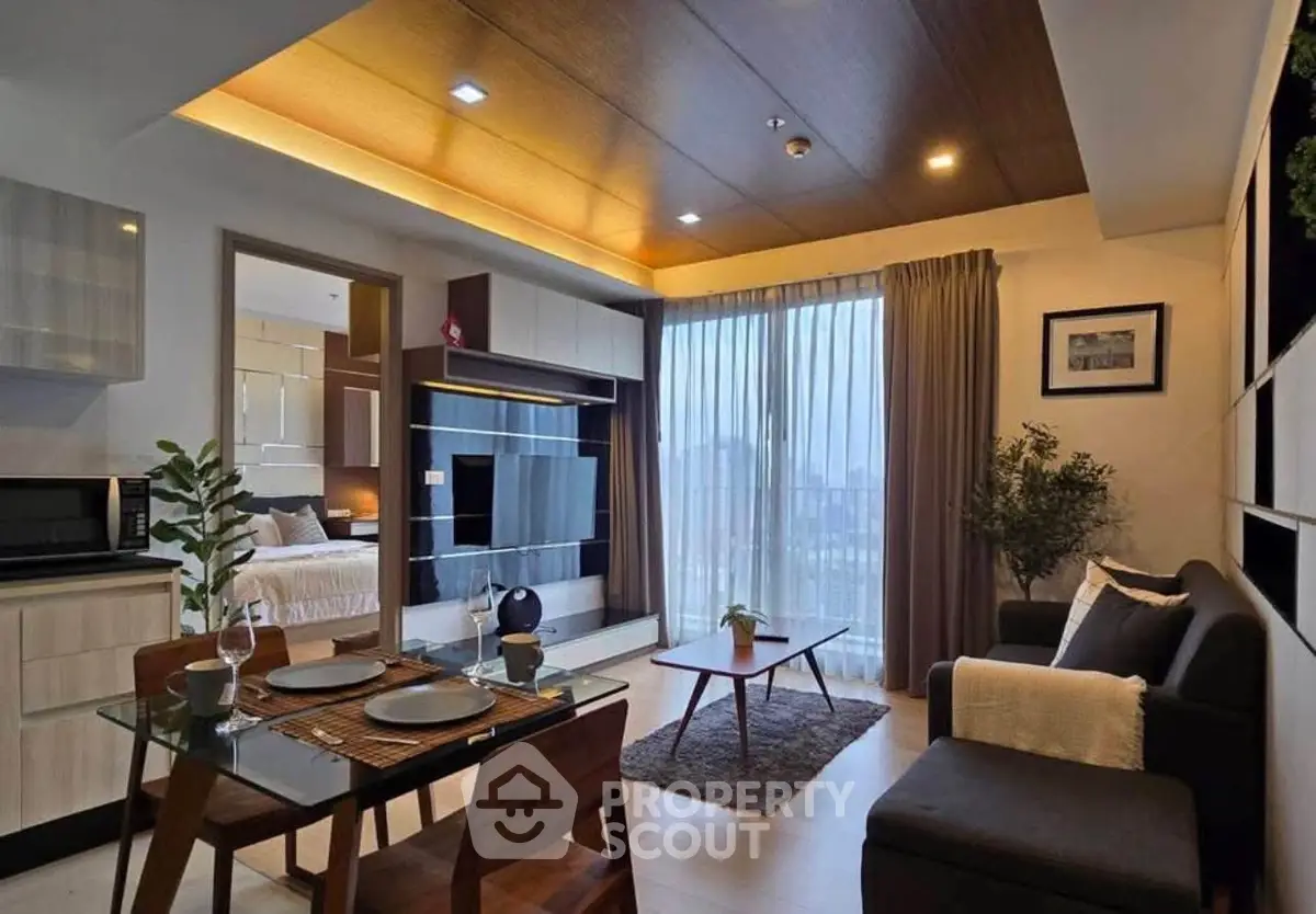 Modern living room with open layout and city view, featuring stylish furniture and decor.