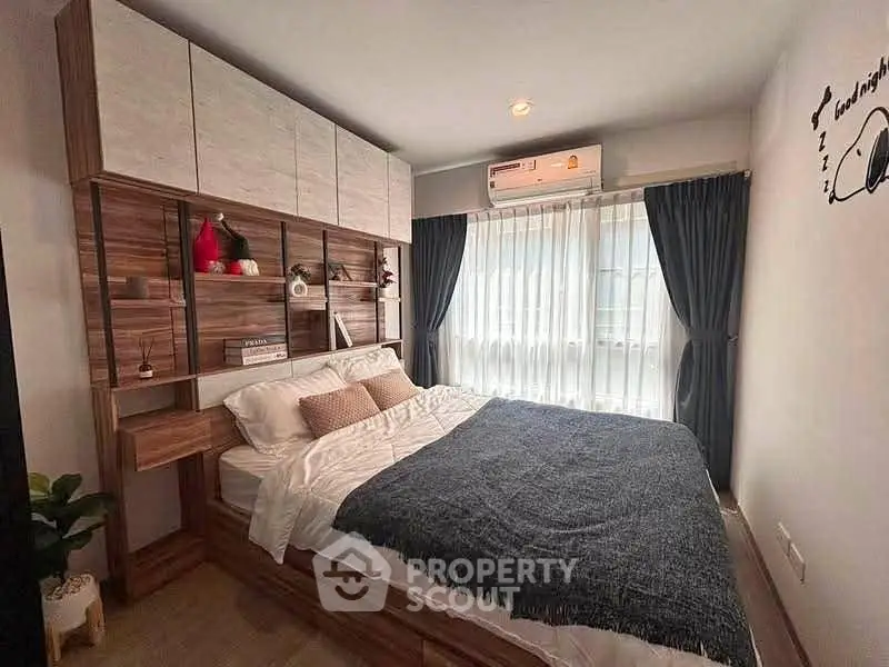 Cozy bedroom with modern wooden furniture and natural light from large window.