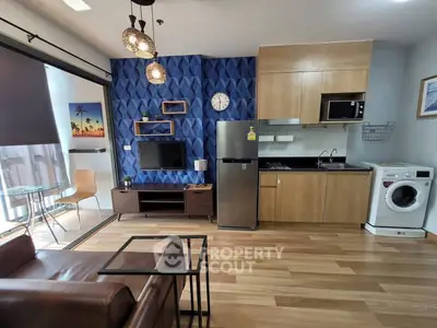 Modern open-layout living room with kitchen, featuring stylish decor and appliances, ideal for urban living.