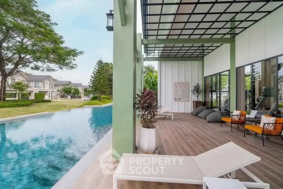 Luxurious poolside view with modern patio and lush greenery in upscale residential area.