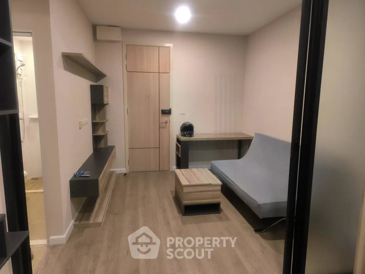 Modern living room with sleek furniture and wooden flooring in a stylish apartment.