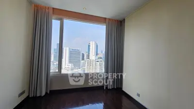 Spacious room with stunning city view and large window in modern apartment.