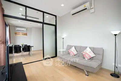 Modern living room with sleek glass partition and cozy seating area