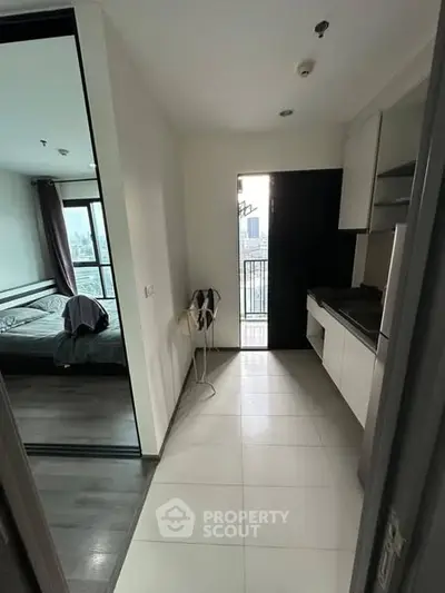 Modern apartment with compact kitchen and balcony view