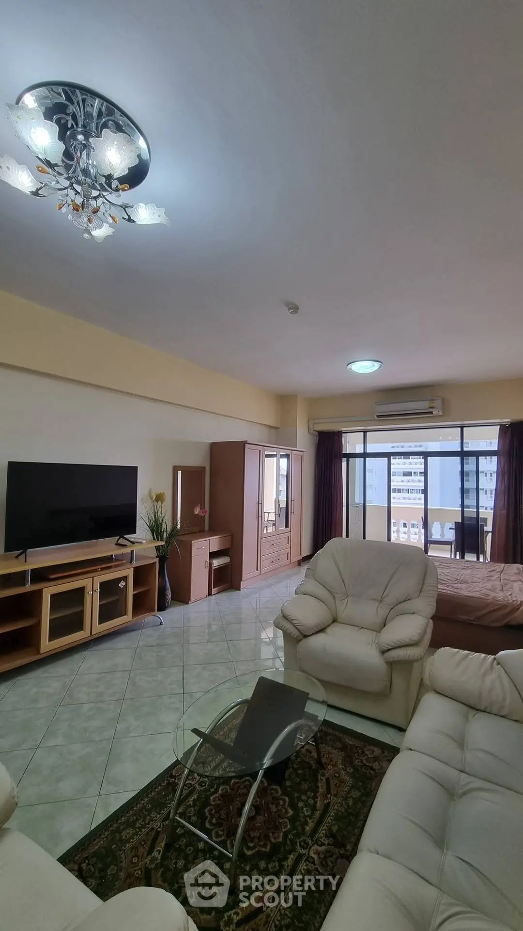 Spacious living room with modern furniture and large windows offering city views.