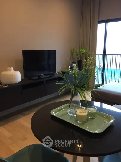 Modern living room with stylish decor and balcony view, featuring sleek furniture and elegant design.