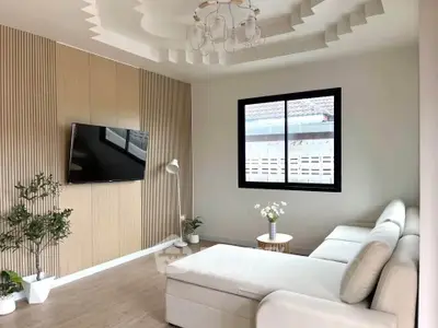 Modern living room with stylish ceiling design and cozy white sectional sofa.